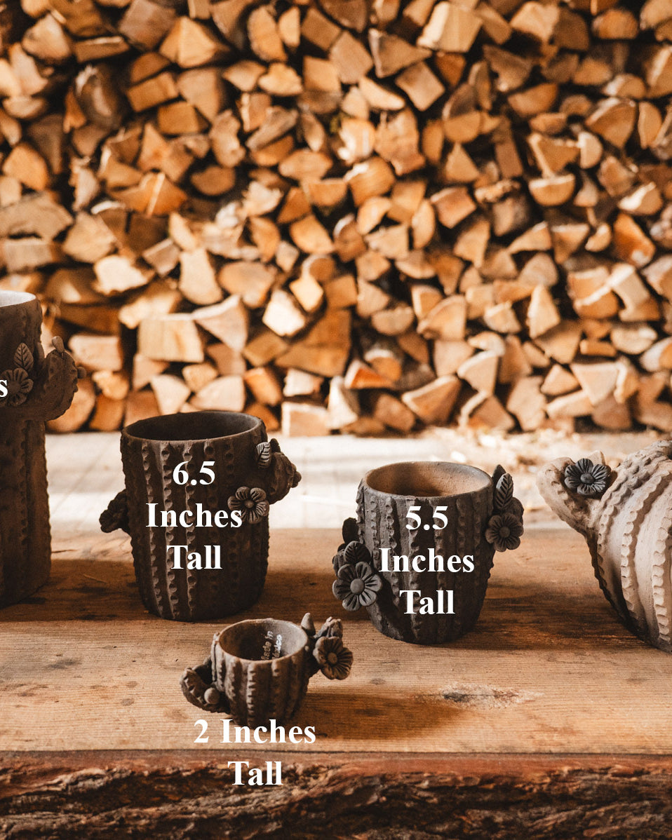 Set of ceramic pots with height measurements against a wooden background