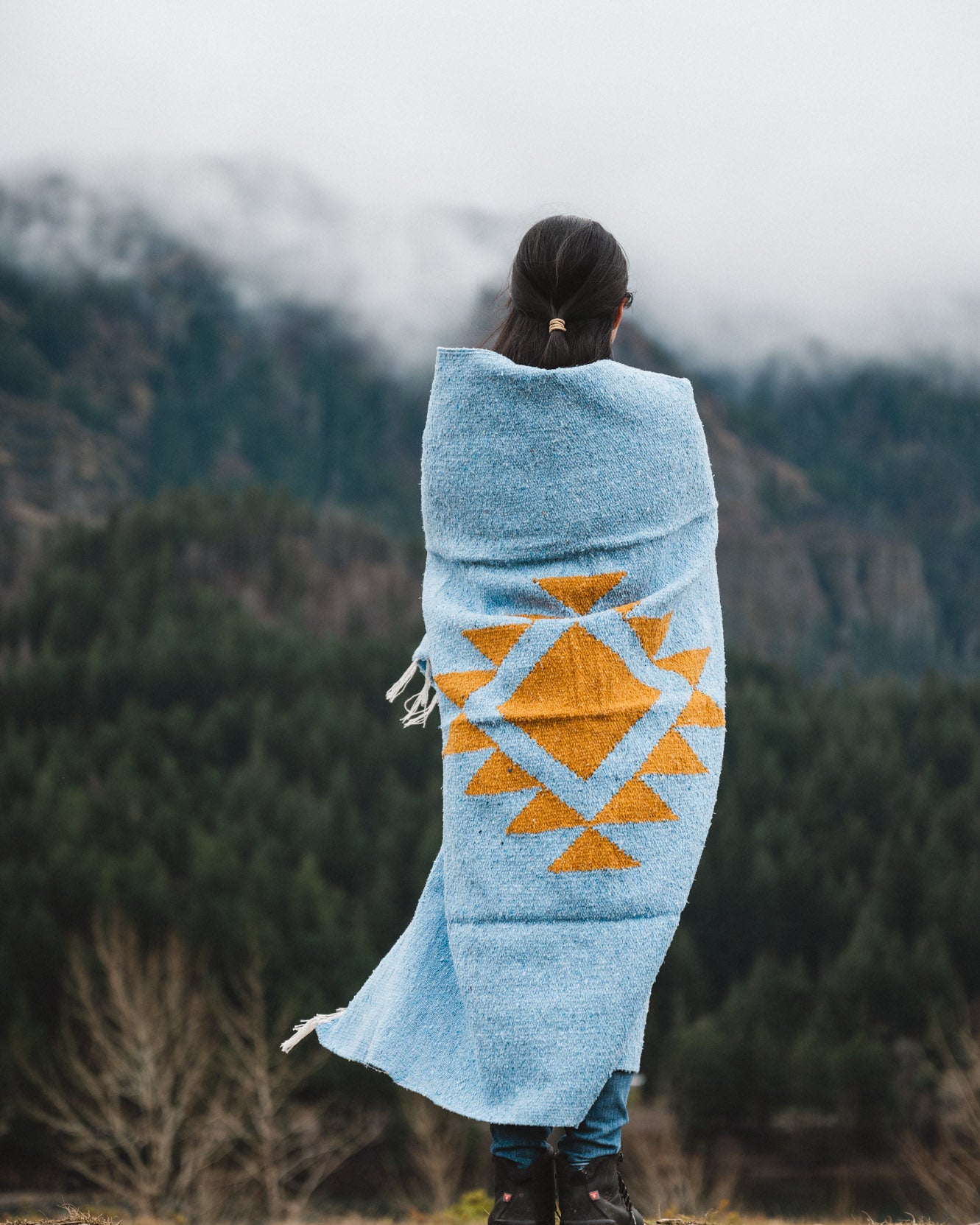 Woman wrapped in blue handwoven mexican blanket