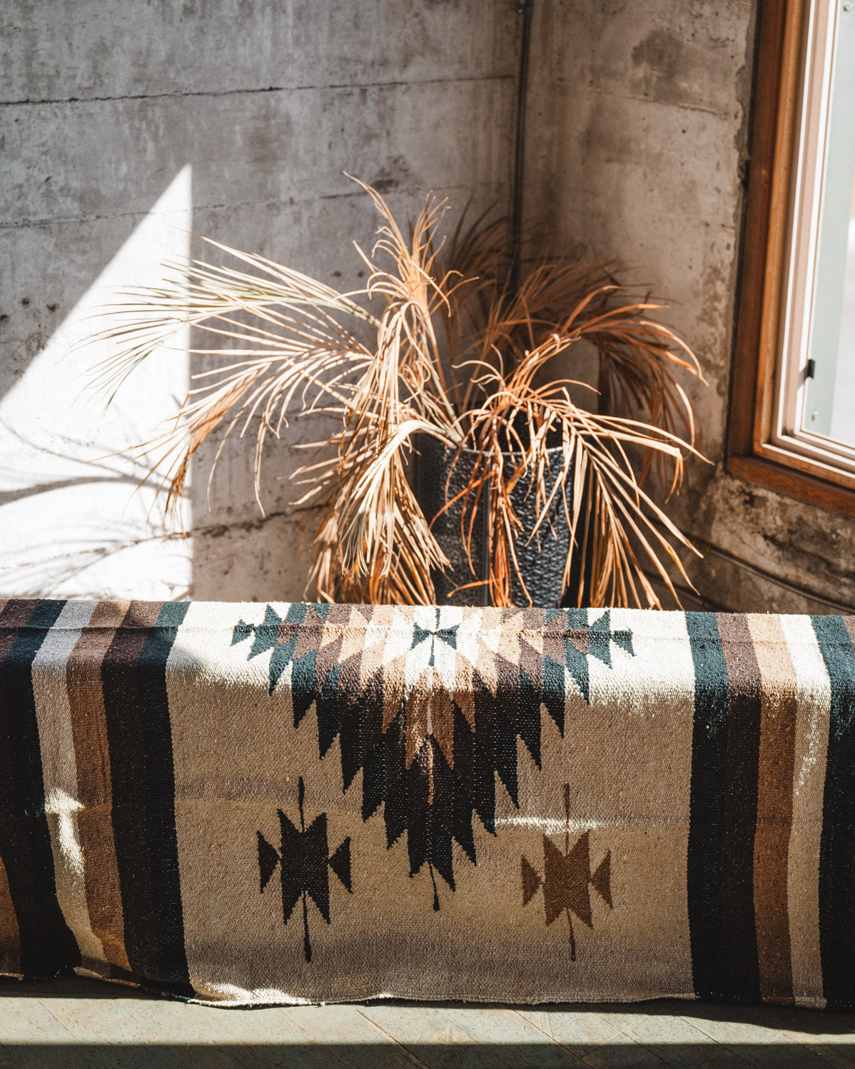 Brown beige and neutral colored handwoven Mexican blanket in urban loft setting