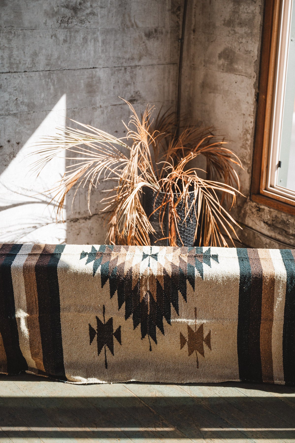 Brown beige and neutral colored handwoven Mexican blanket in urban loft setting