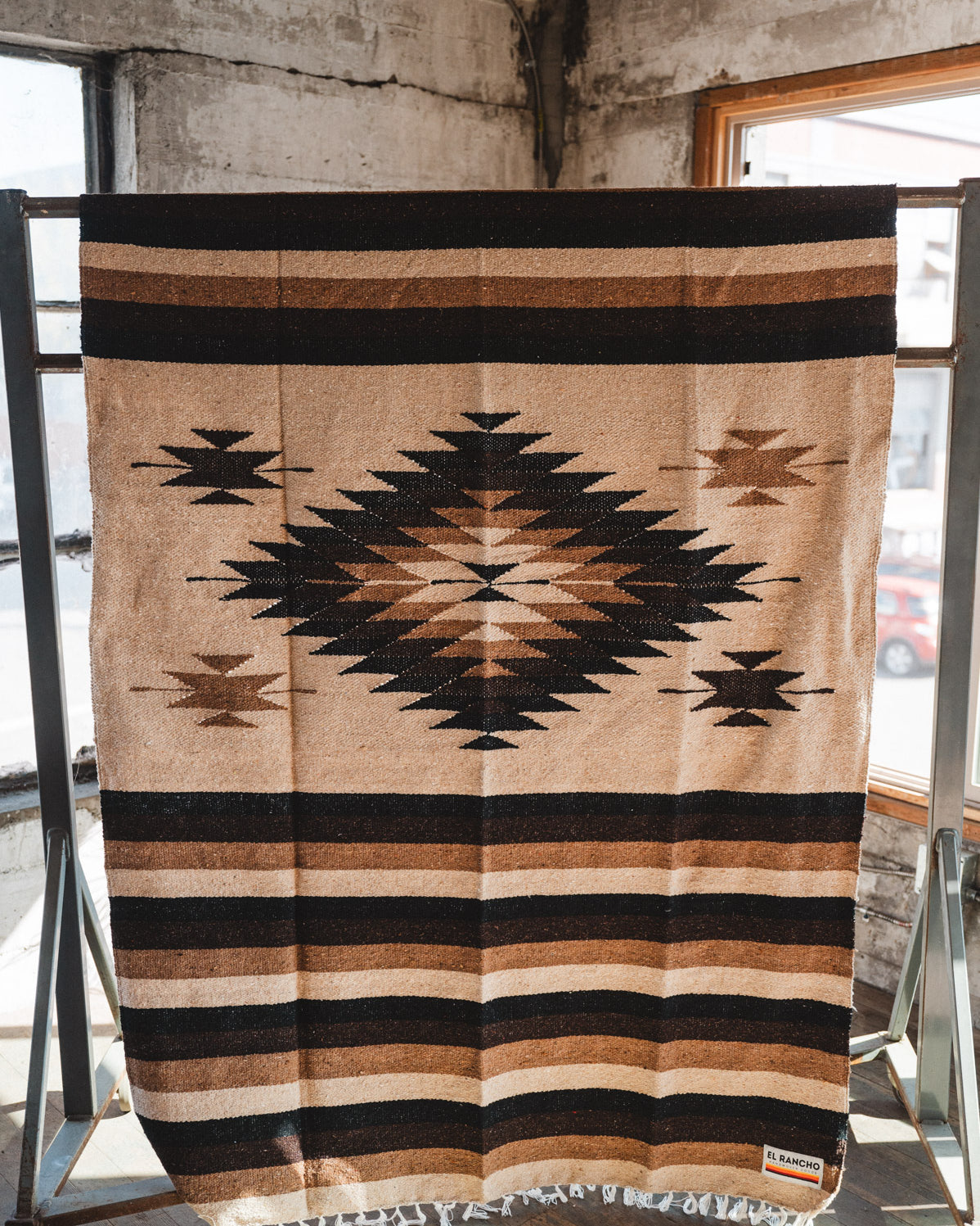 Brown beige and neutral colored handwoven Mexican blanket in urban loft setting