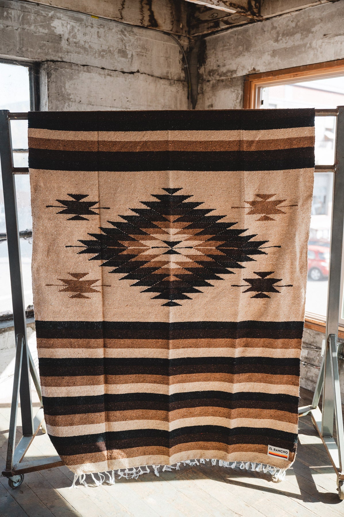 Brown beige and neutral colored handwoven Mexican blanket in urban loft setting