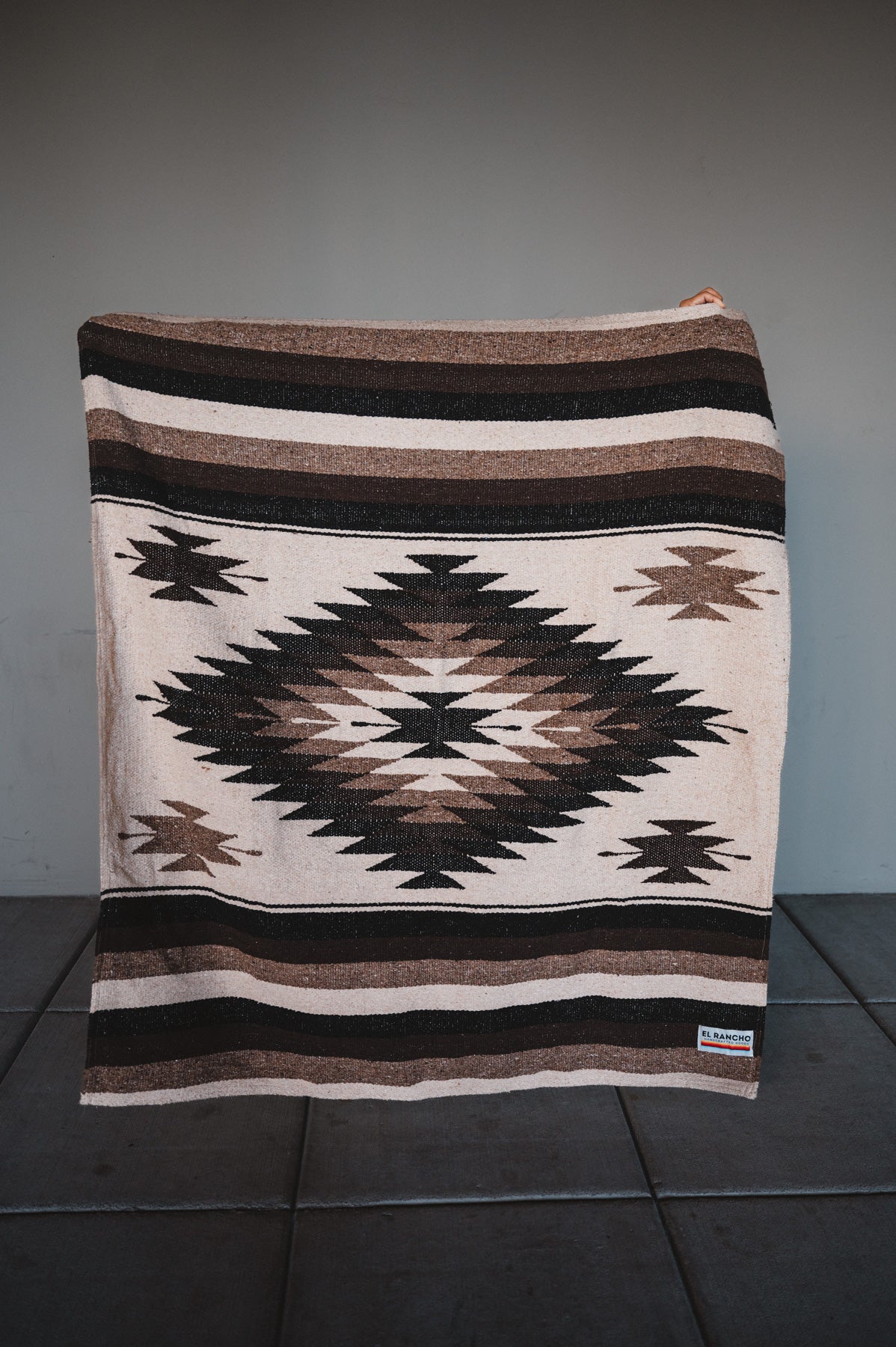 Brown handwoven mexican blanket for dogs against concrete background