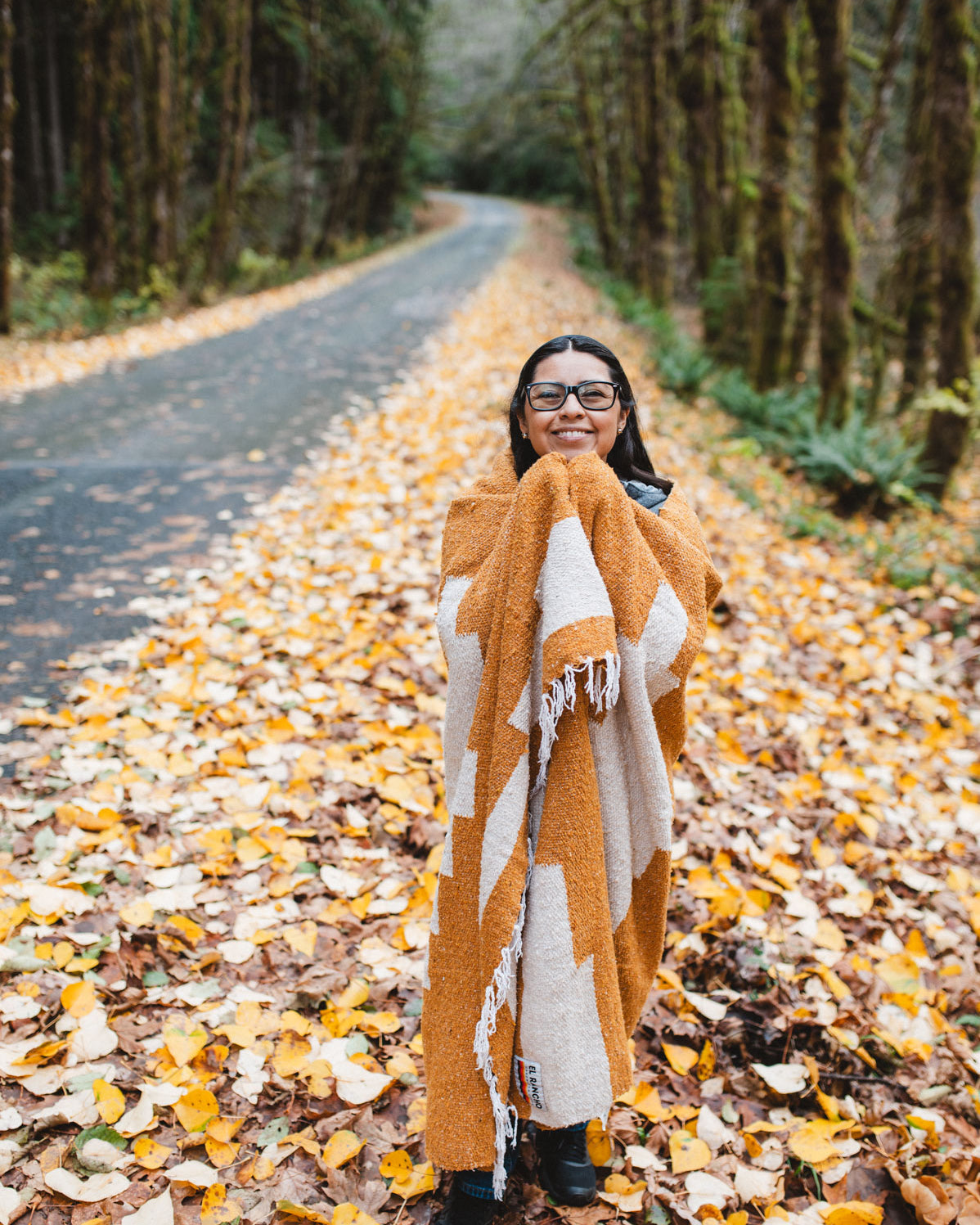 Orange blanket wrapped around girl on side of road