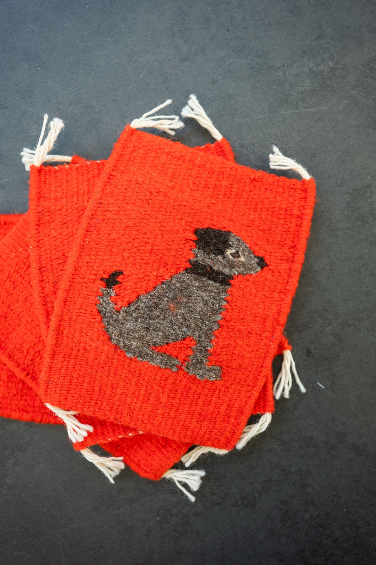 Handwoven wool coaster from Teotitlan Del Valle of a dog on red background