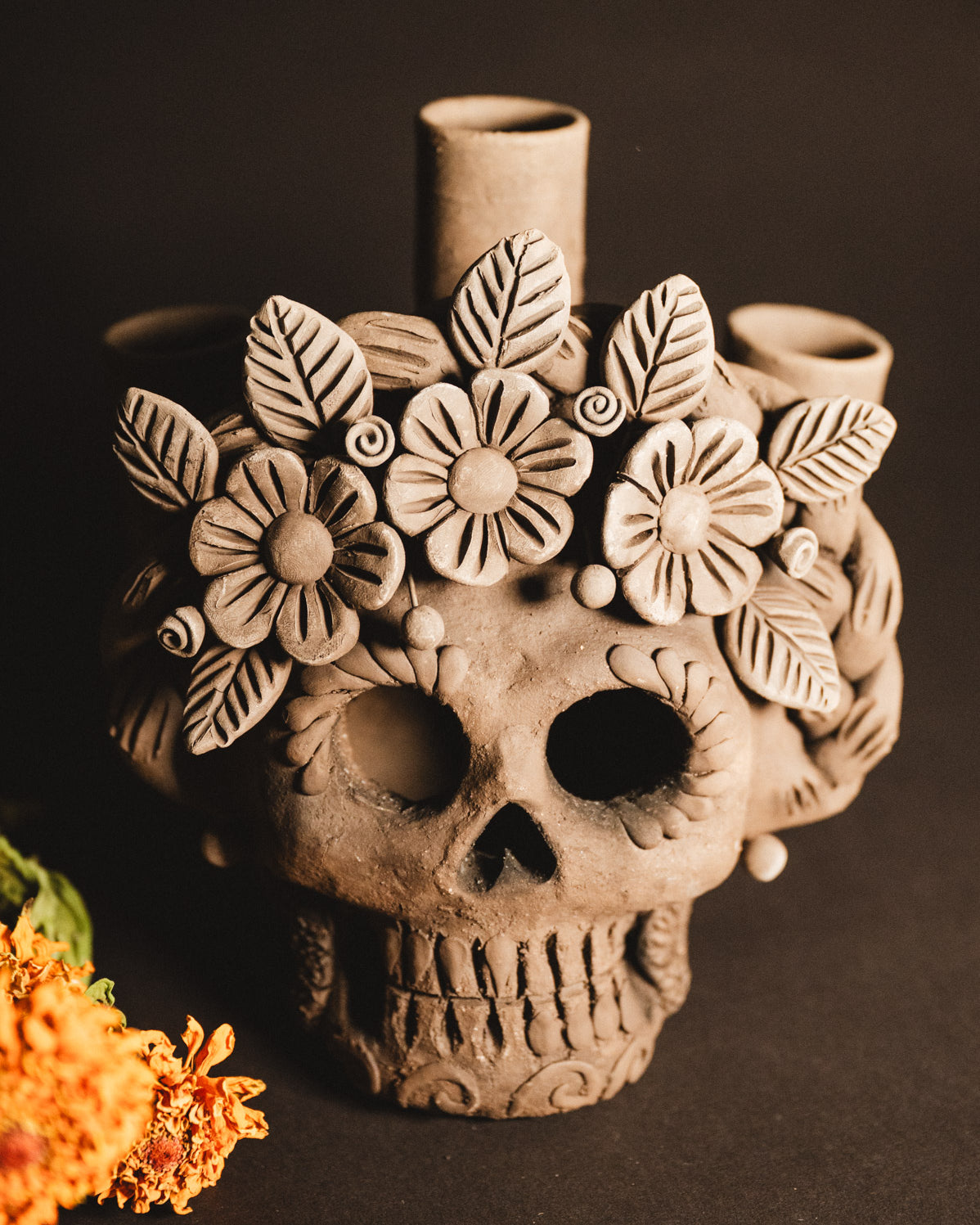 Ceramic skull with floral designs on a dark background