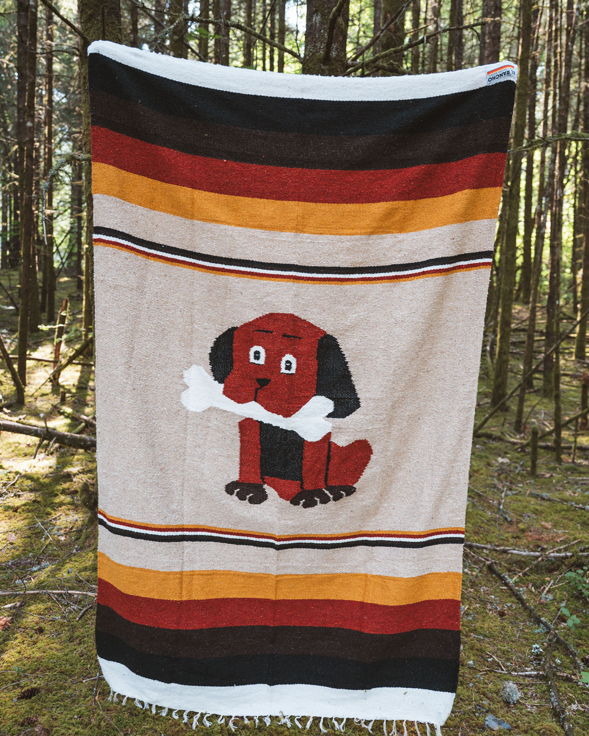 Dog themed handwoven mexican blanket in a forest background