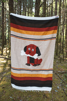 Dog themed handwoven mexican blanket in a forest background