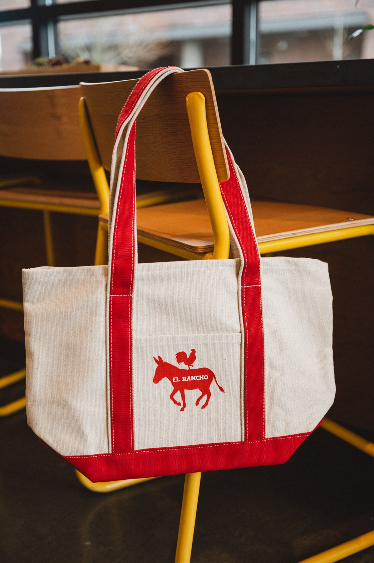 Red and white tote bag with a logo on a chair