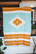 andwoven Mexican Blanket Turquoise and gold color Diamond pattern in modern industrial setting