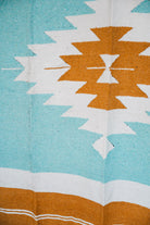 andwoven Mexican Blanket Turquoise and gold color Diamond pattern in modern industrial setting