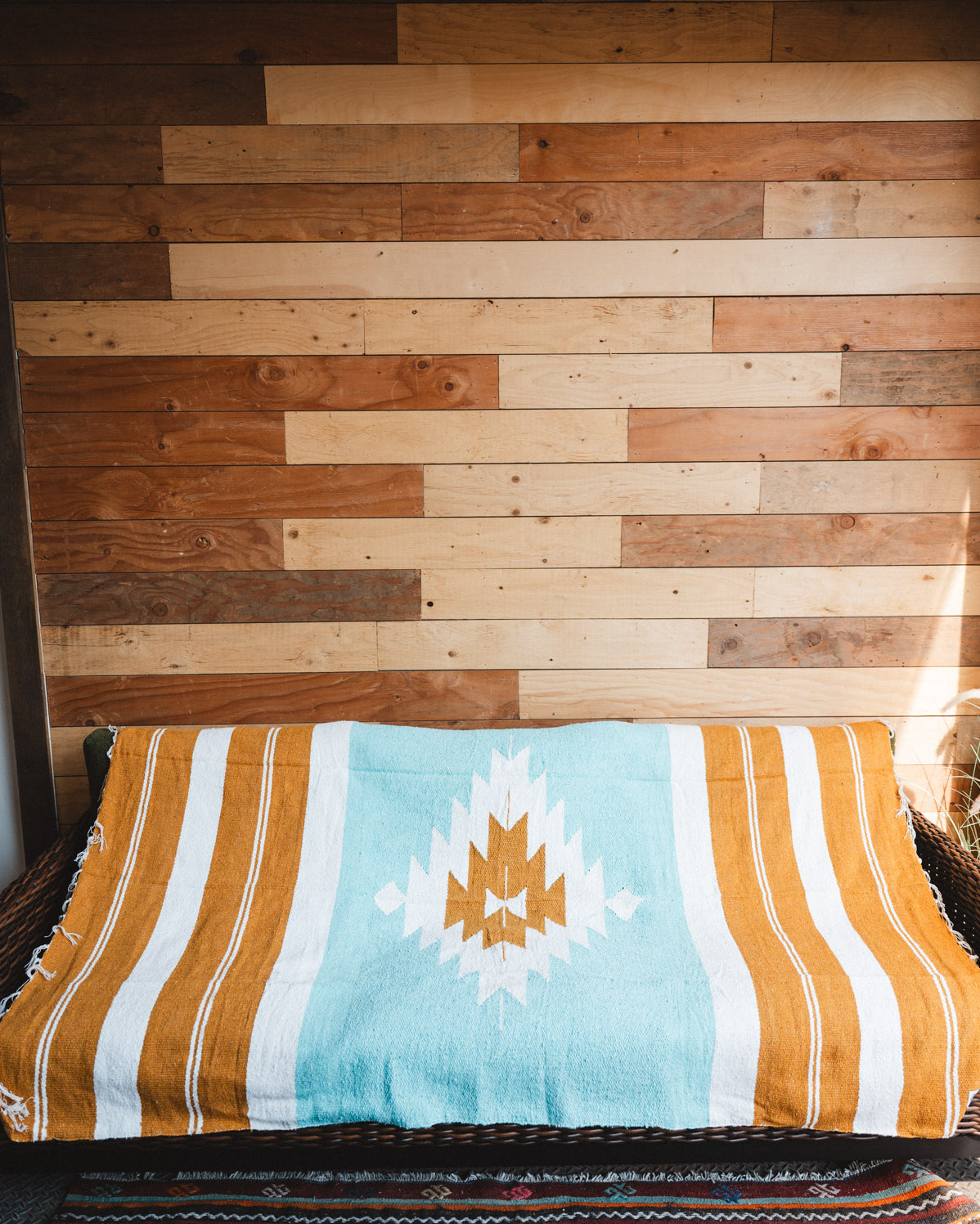 andwoven Mexican Blanket Turquoise and gold color Diamond pattern in modern industrial setting