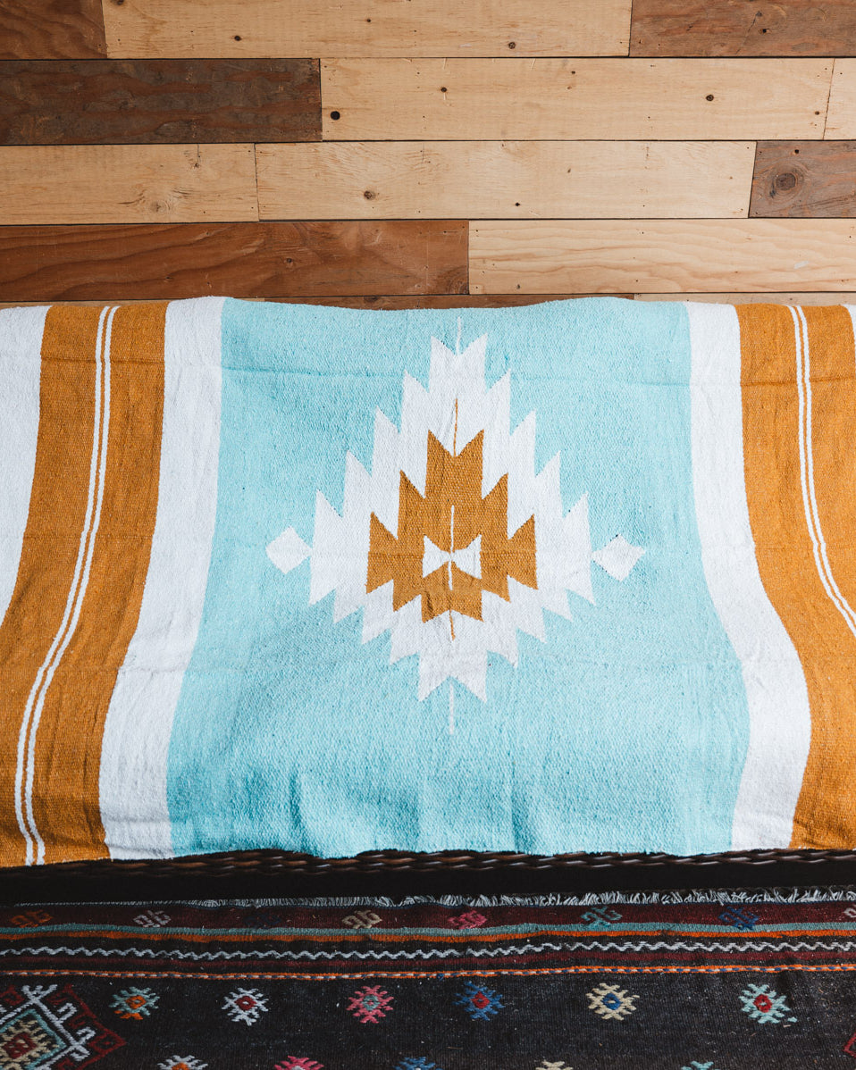 Handwoven Mexican Blanket Turquoise and gold color Diamond pattern in modern industrial setting