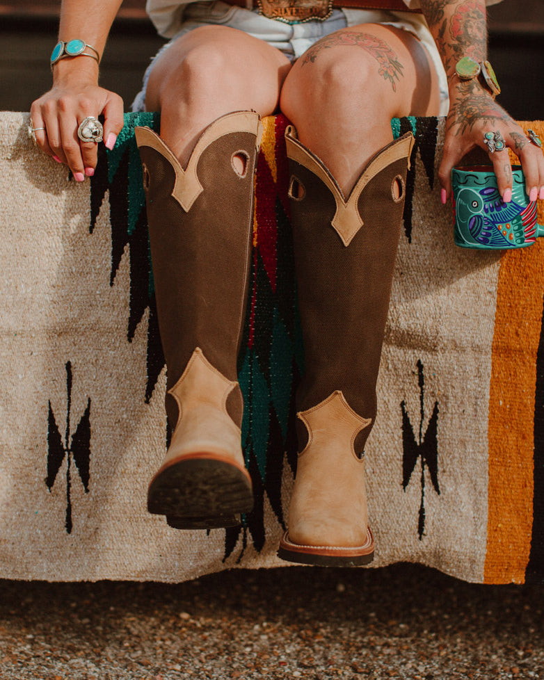 Girl sitting on diamond blanket in cowboy boots