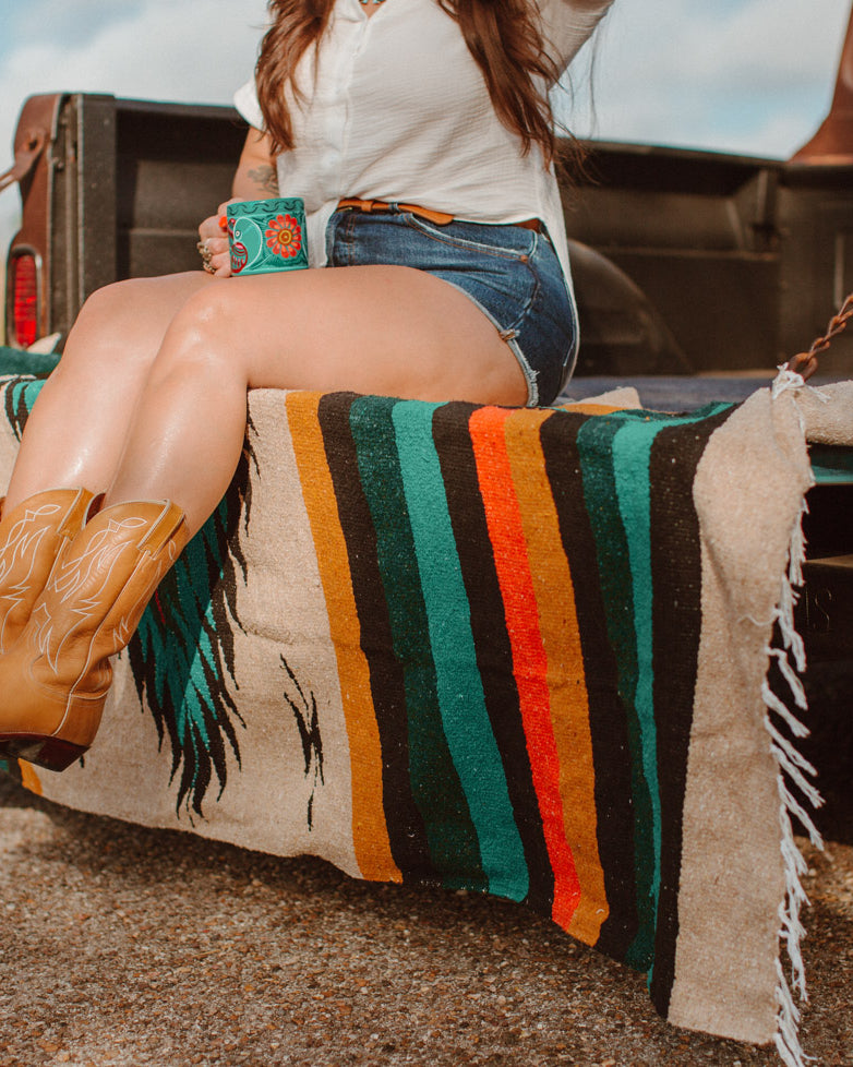 Girl sitting on diamond blanket in cowboy boots