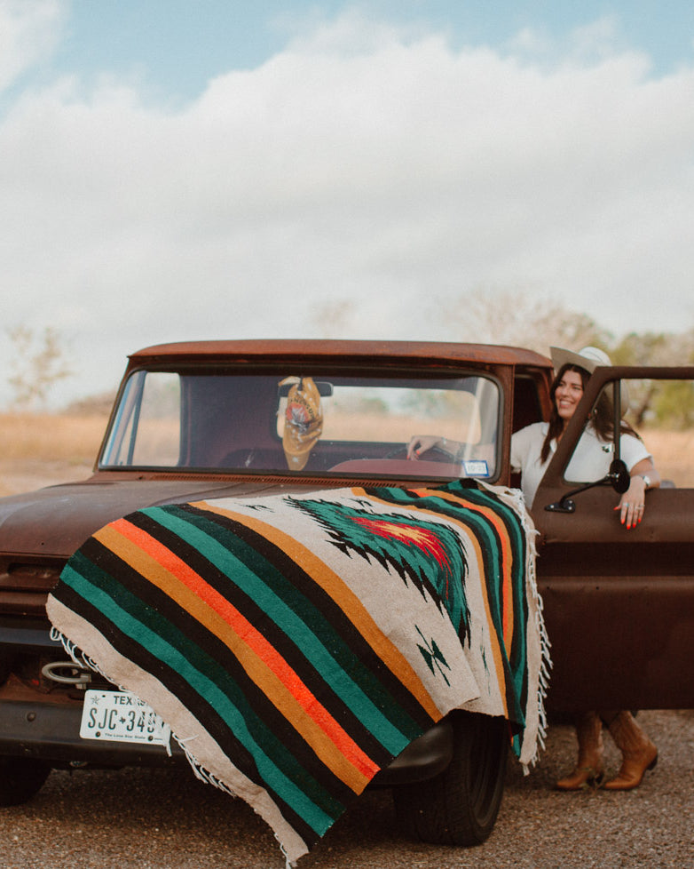 Diamond blanket sitting on the hood of a vintage pickup truck