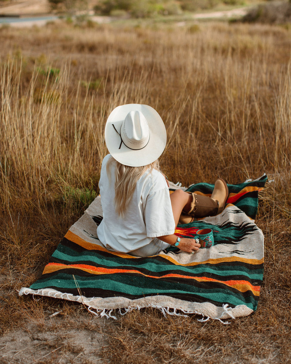 Girl sitting on diamond blanket in cowboy boots