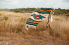 Girl spreading out diamond blanket in a field of tall dry grass