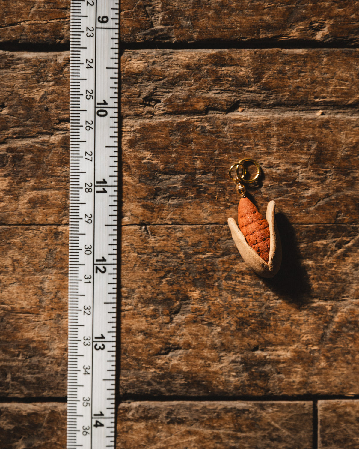 Elote clay pendant on wood floor