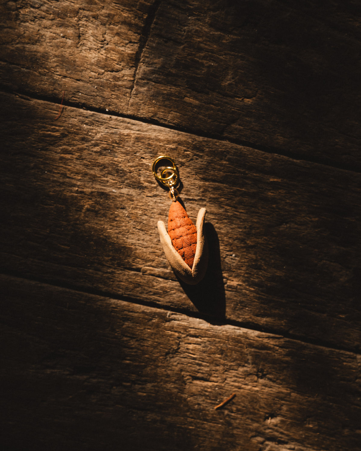 handmade clay elote pendant on wood floor