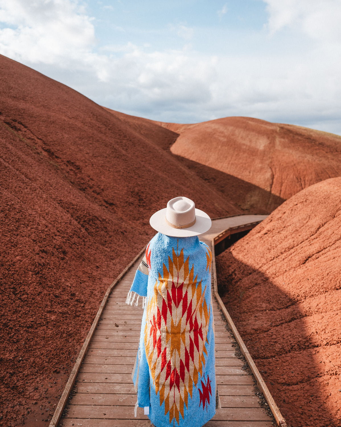 Painted Hills Oregon with a woman wearing a blue mexican blanket