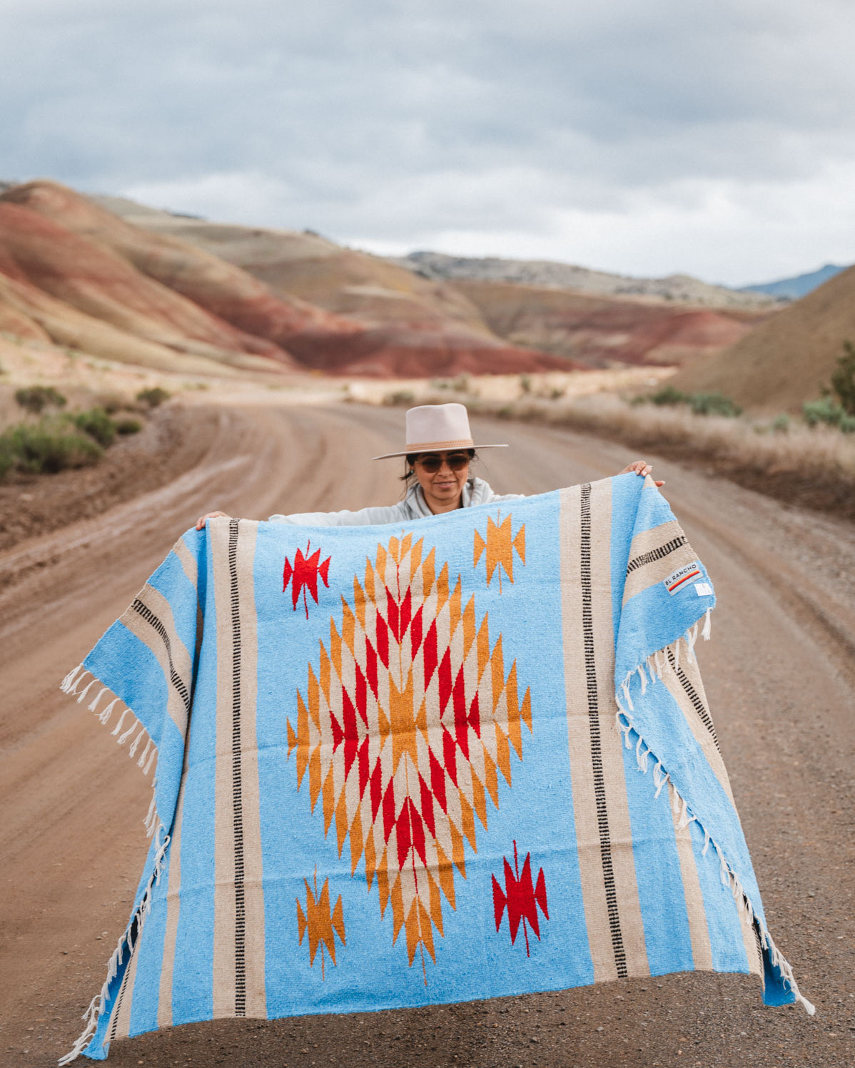 Painted Hills Oregon with a woman wearing a blue mexican blanket