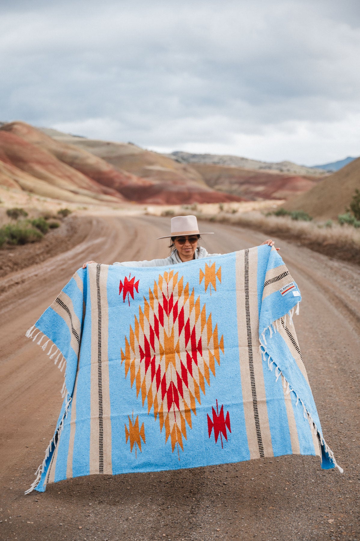 Painted Hills Oregon with a woman wearing a blue mexican blanket