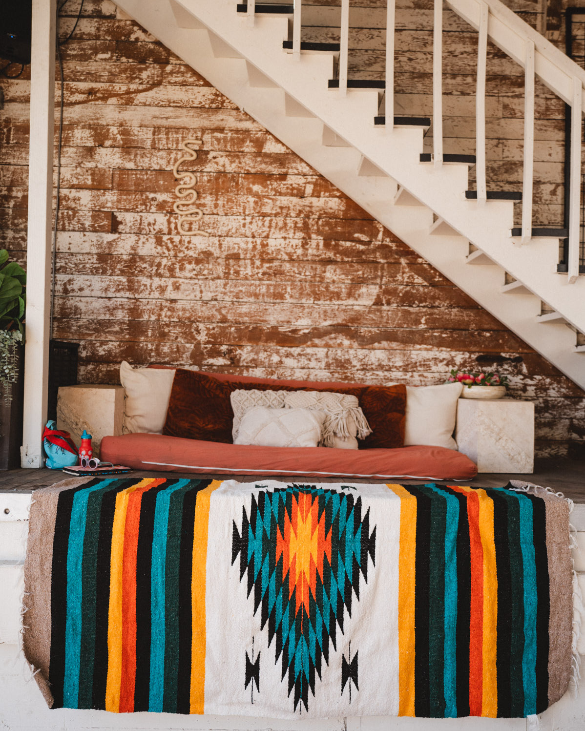 Green white and orange handwoven mexican blanket hanging in urban loft