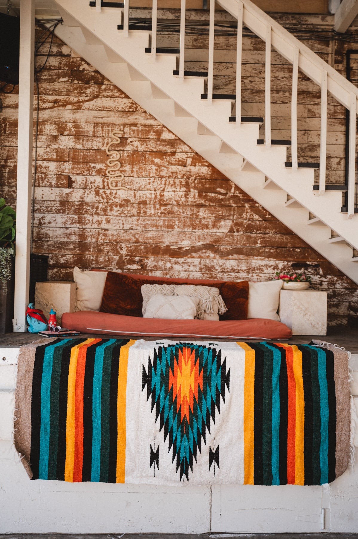 Green white and orange handwoven mexican blanket hanging in urban loft