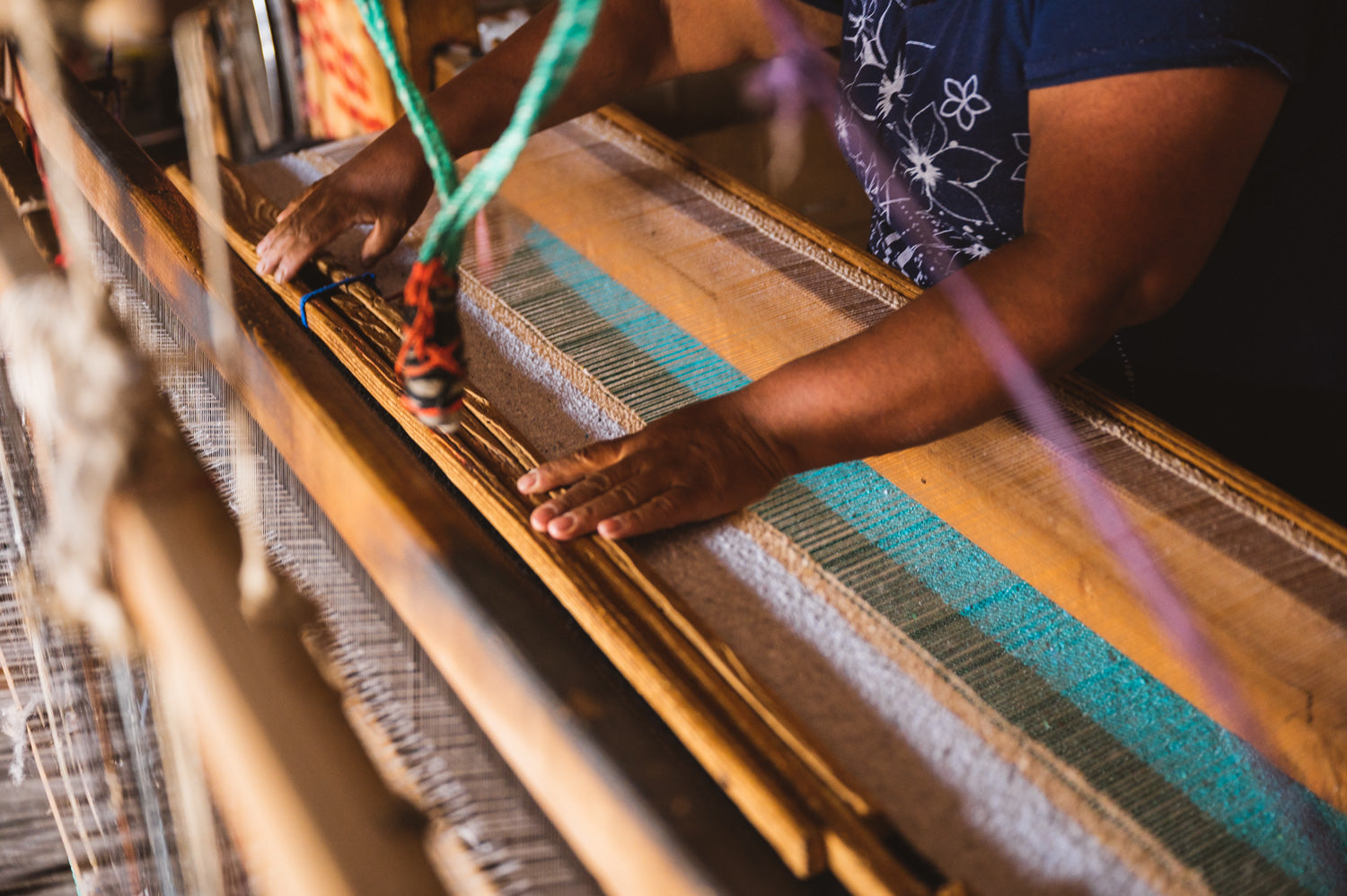 Woman hand weaving colorful blanket on a wooden loom