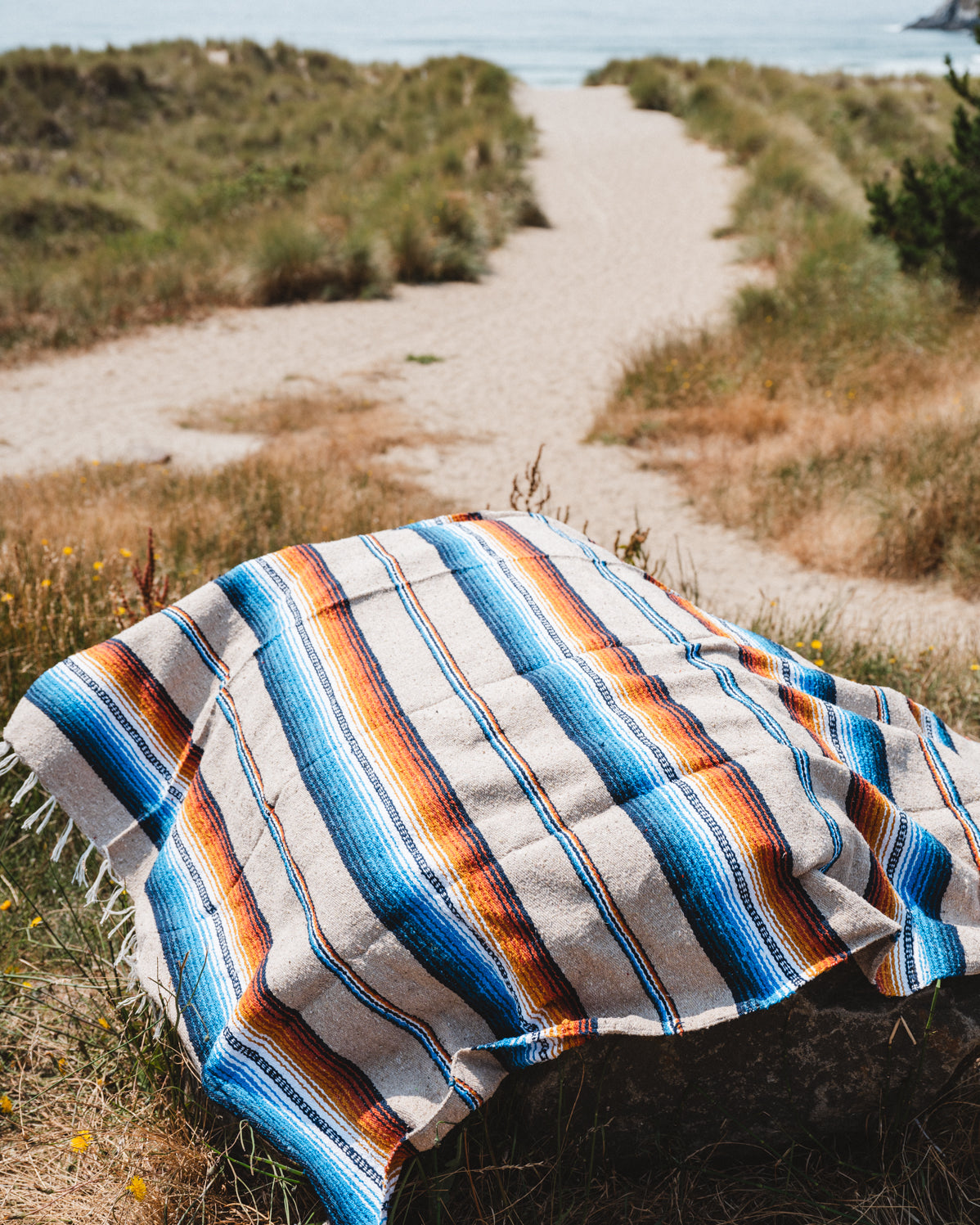Saltillo blanket laying on rock at sand dunes