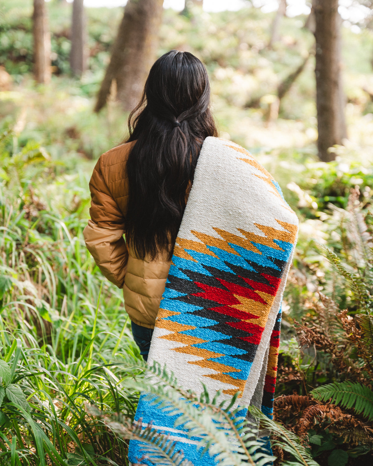 handwoven southwestern diamond sarape being worn by girl in forest