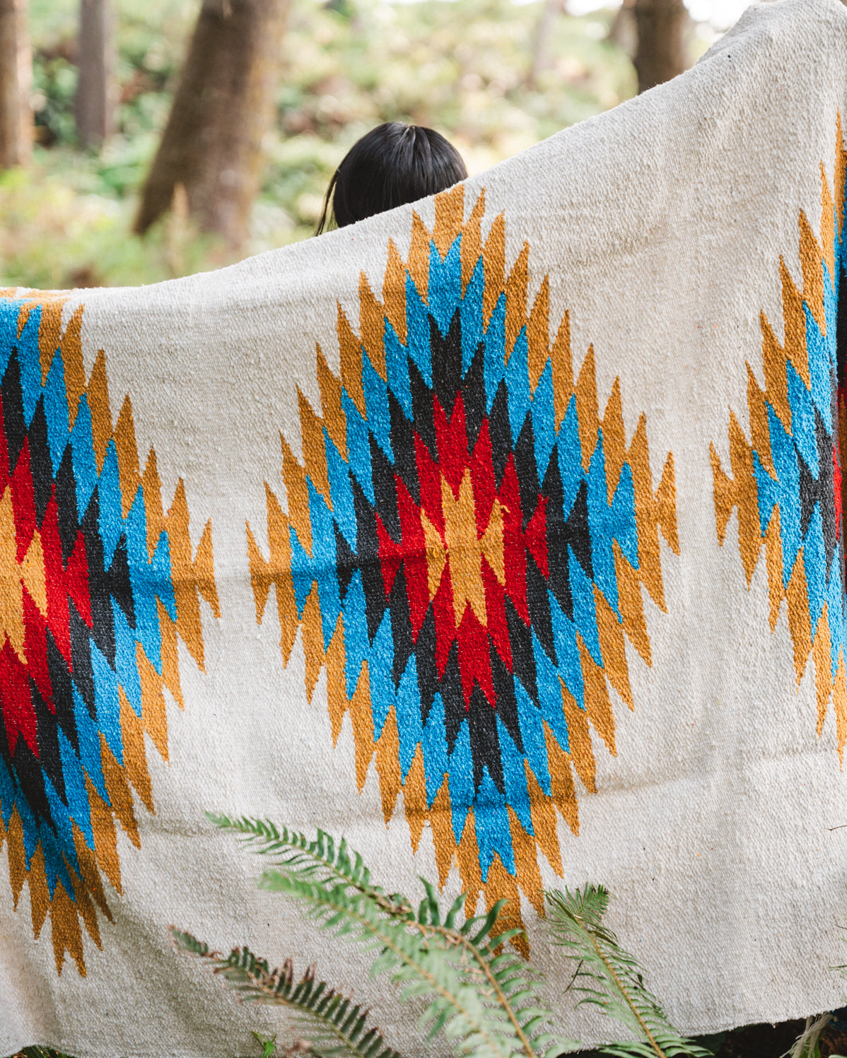 handwoven southwestern diamond sarape being worn by girl in forest