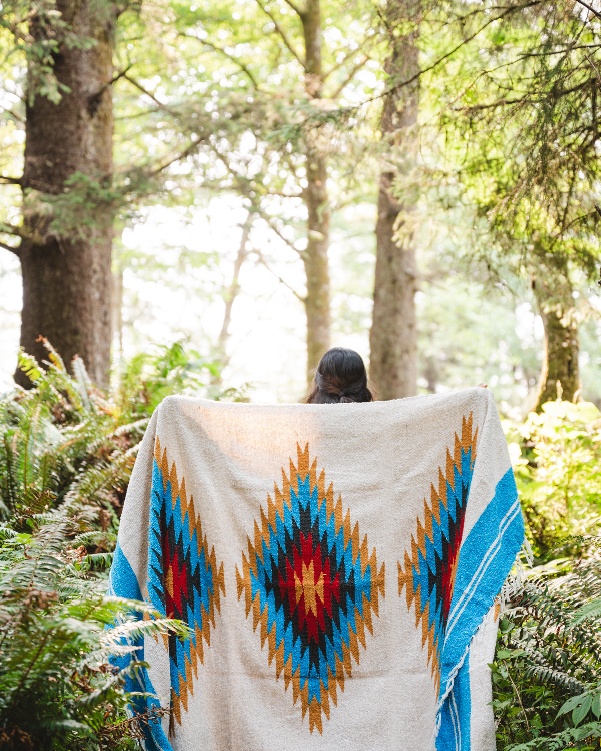 handwoven southwestern diamond sarape being worn by girl in forest