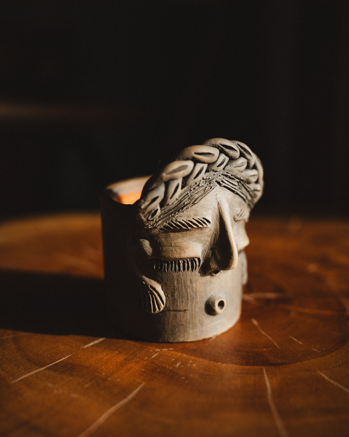 Wooden mask with braided design on a dark background