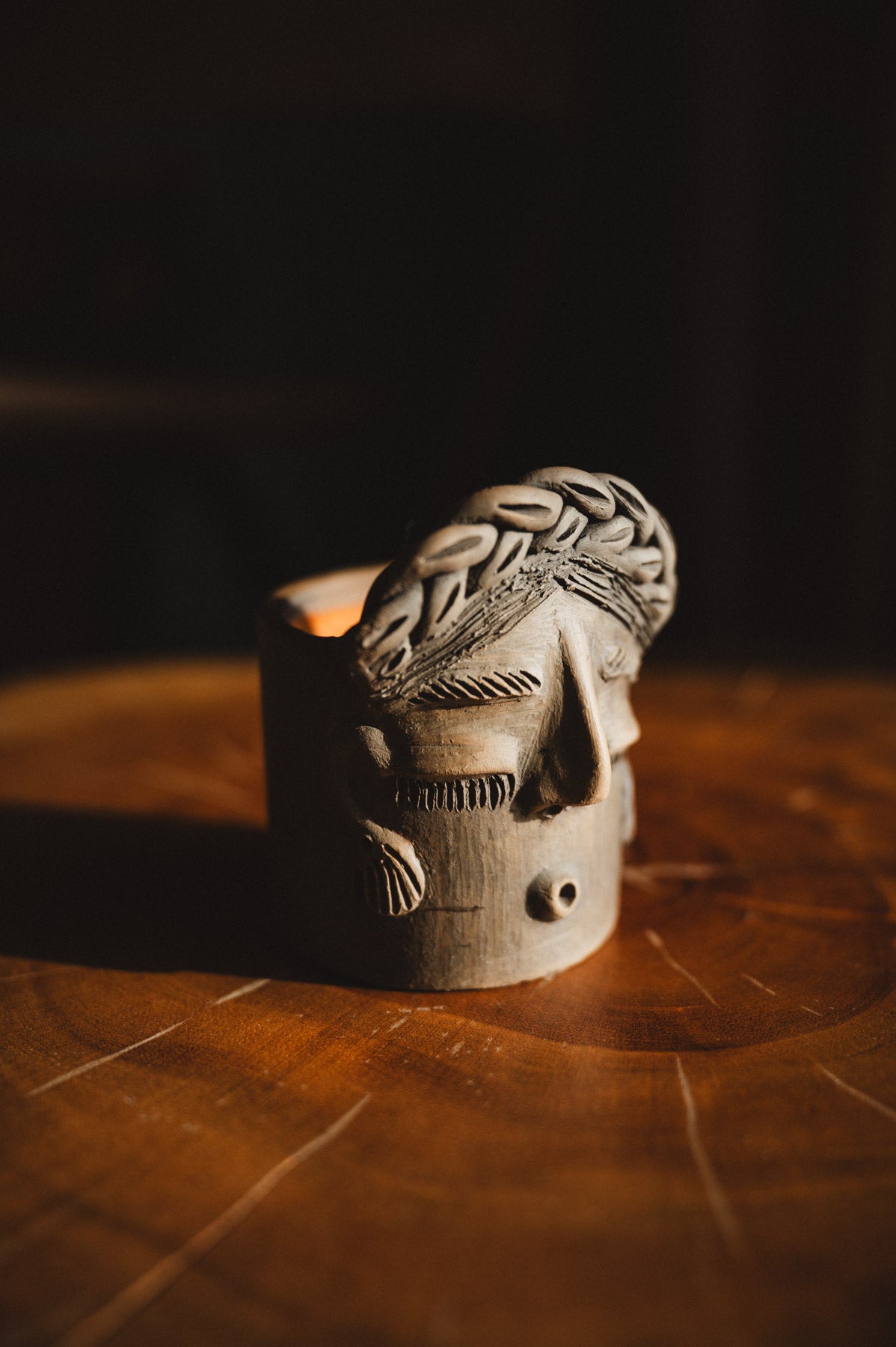 Wooden mask with braided design on a dark background