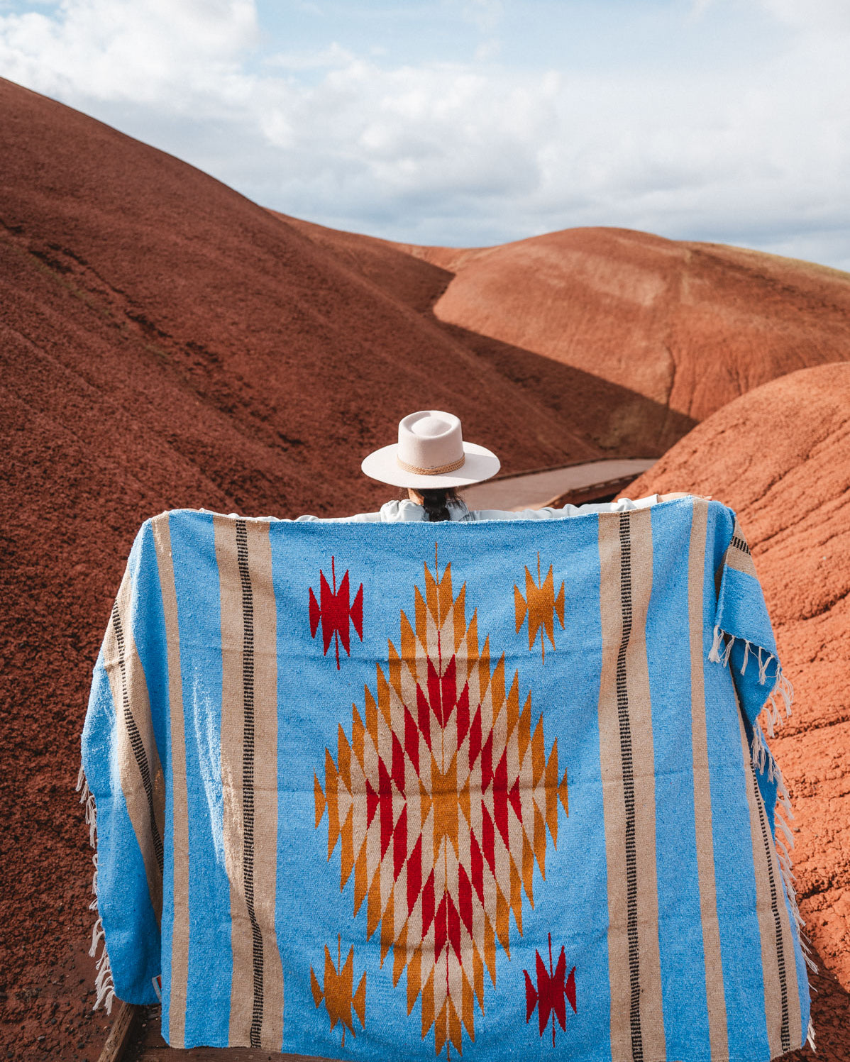 Painted Hills Oregon with a woman wearing a blue mexican blanket