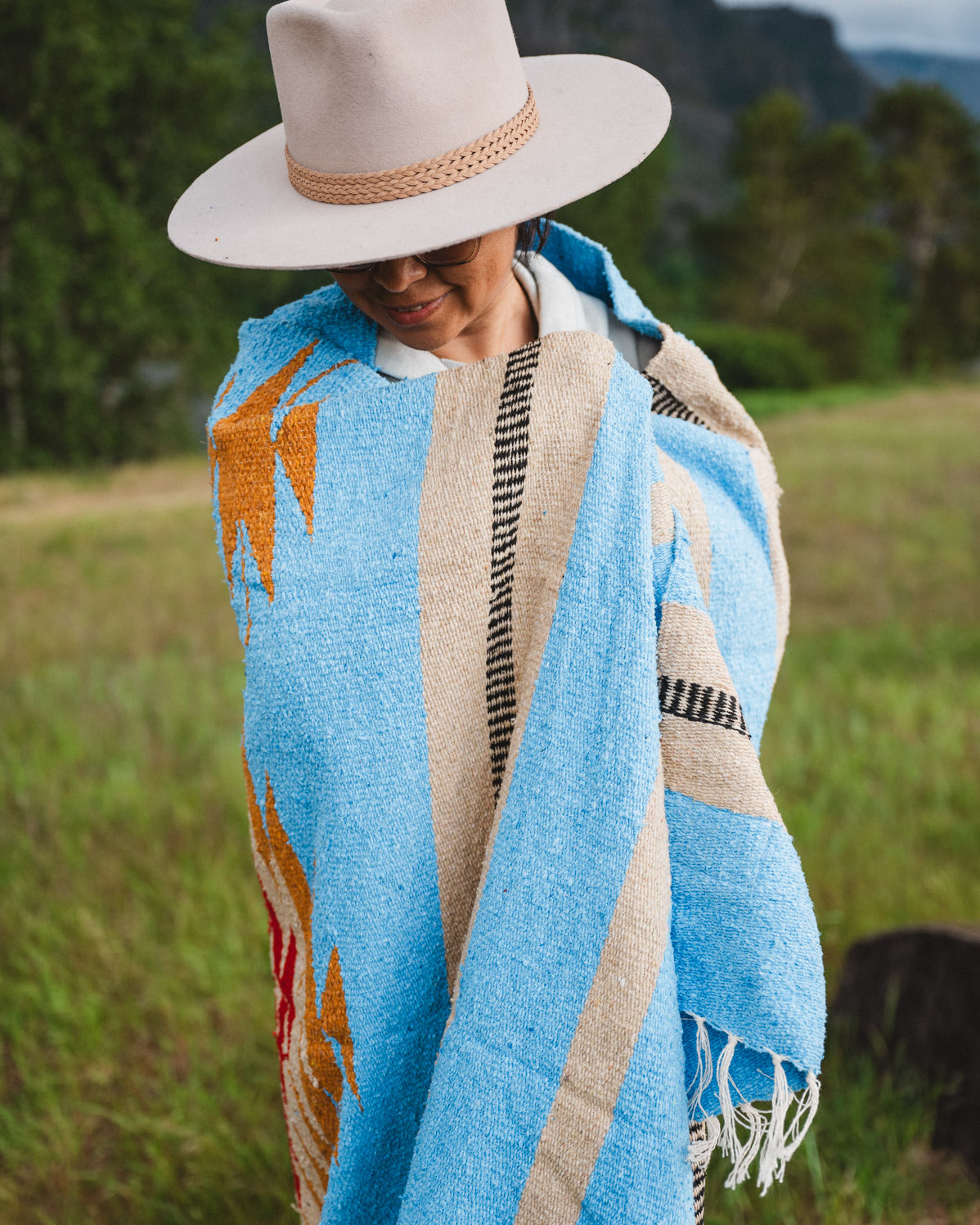 Mexican woman wrapped in blue handwoven mexican blanket