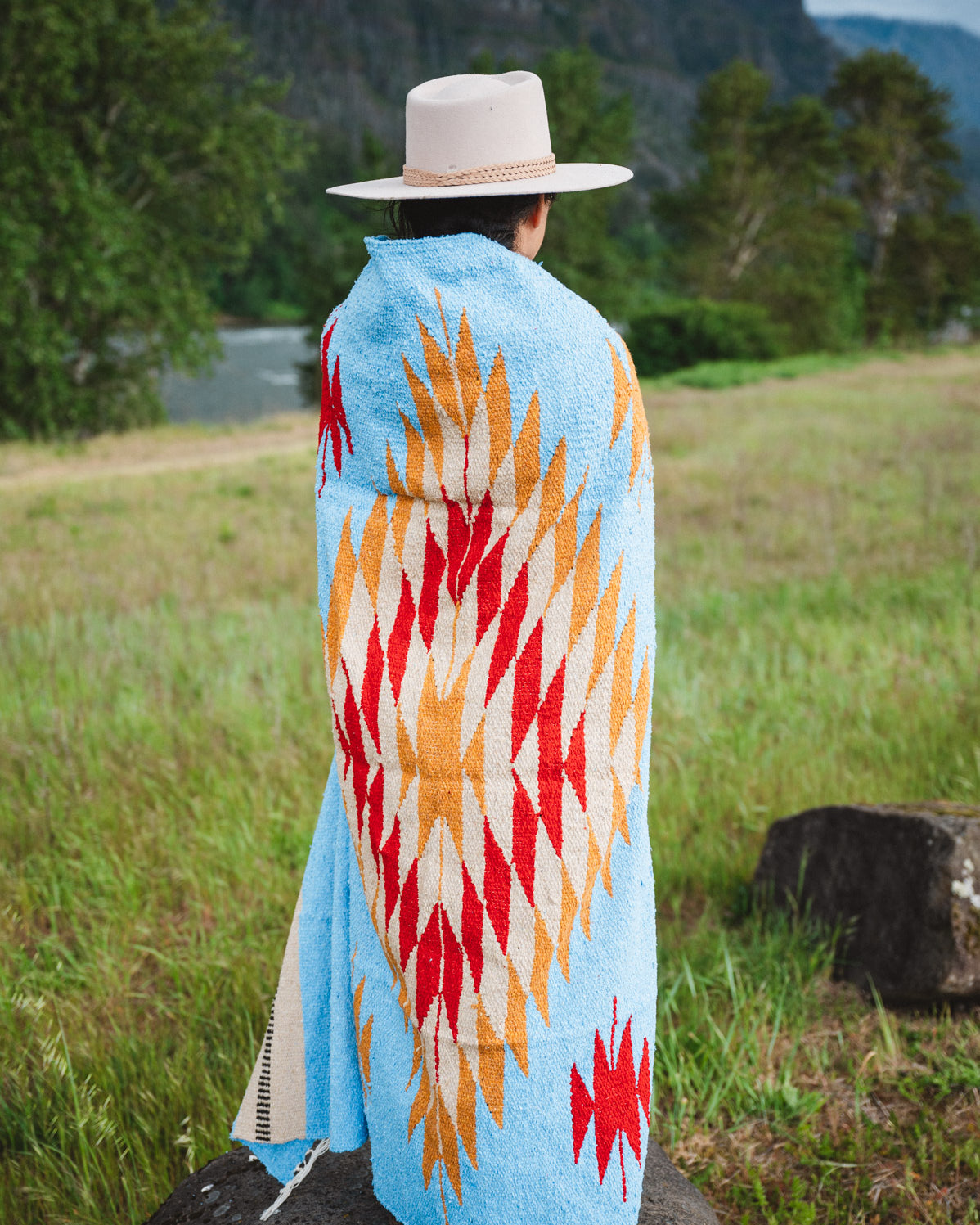 Mexican woman wrapped in blue handwoven mexican blanket
