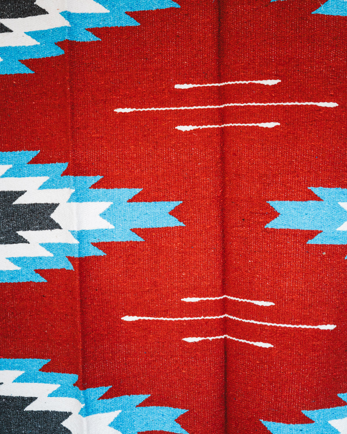 Handwoven Mexican Blanket Red, blue and black Relampago pattern in modern industrial setting