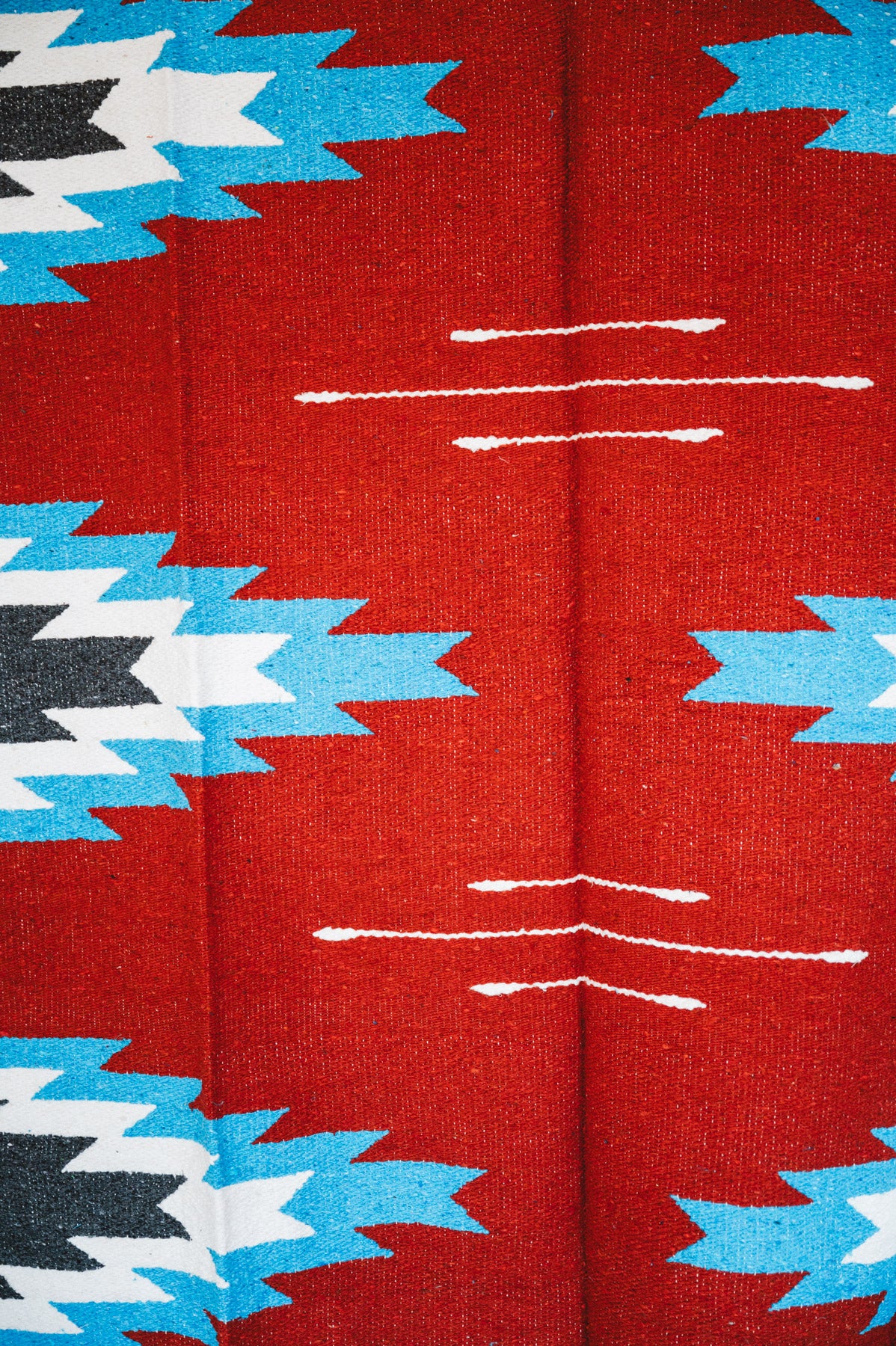 Handwoven Mexican Blanket Red, blue and black Relampago pattern in modern industrial setting