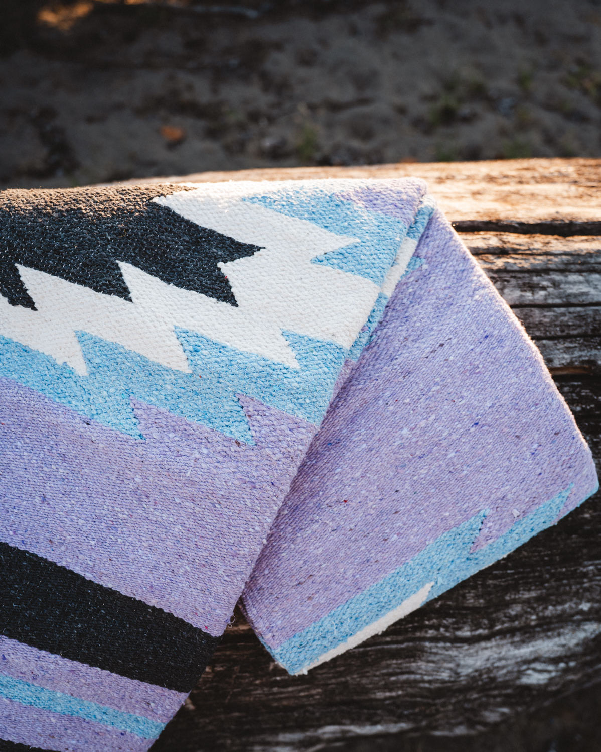 Colorful patterned rug with geometric design on a wooden surface