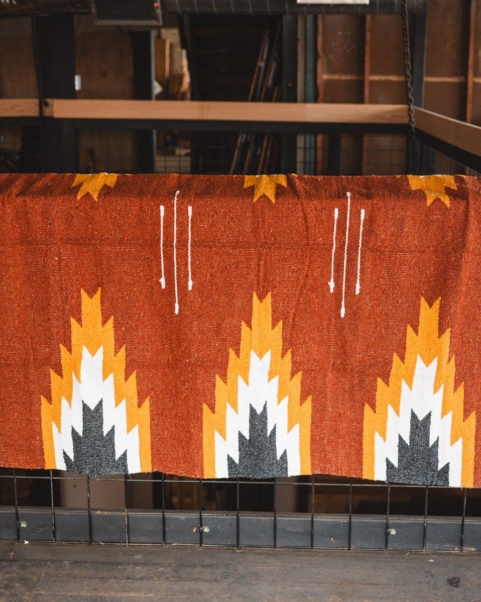 Woven blanket with geometric pattern on a wooden surface