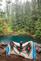 Woman wearing a Handwoven Mexican Blanket in front of Blue Pool, Oregon in the Mckenzie River Corridor
