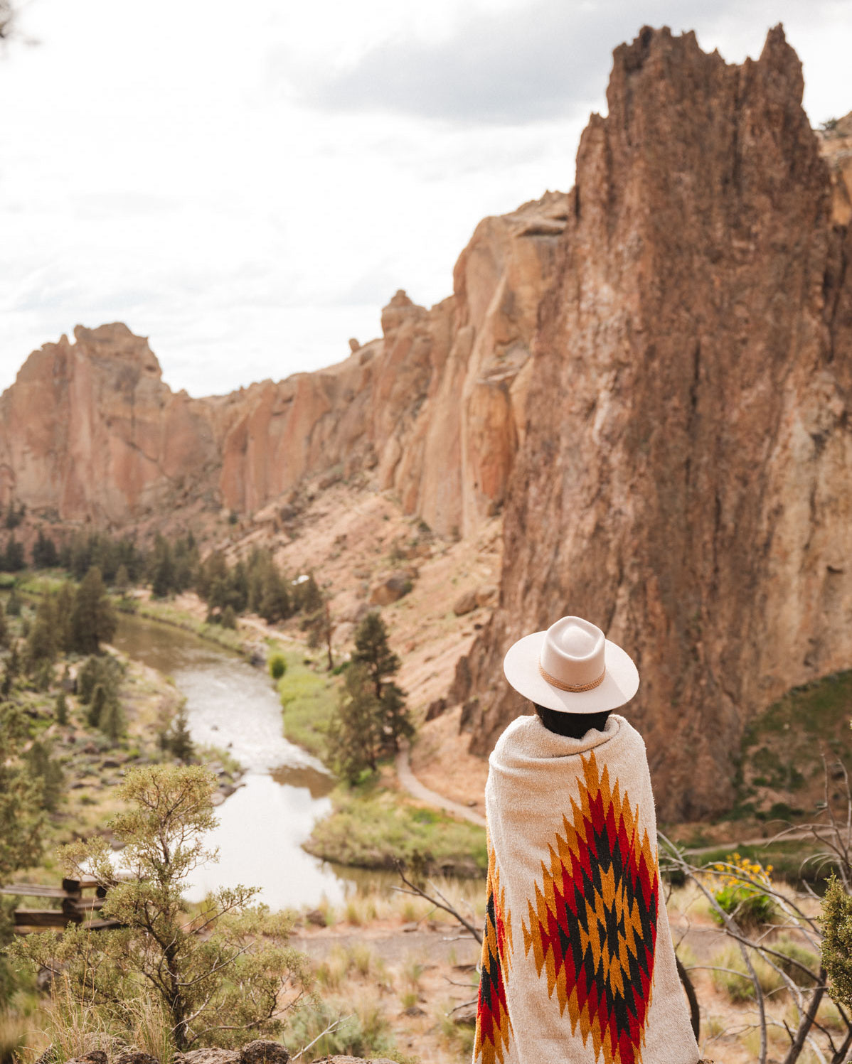 Woman wearing a southwest diamond handwoven blanket at smith rock state park oregon