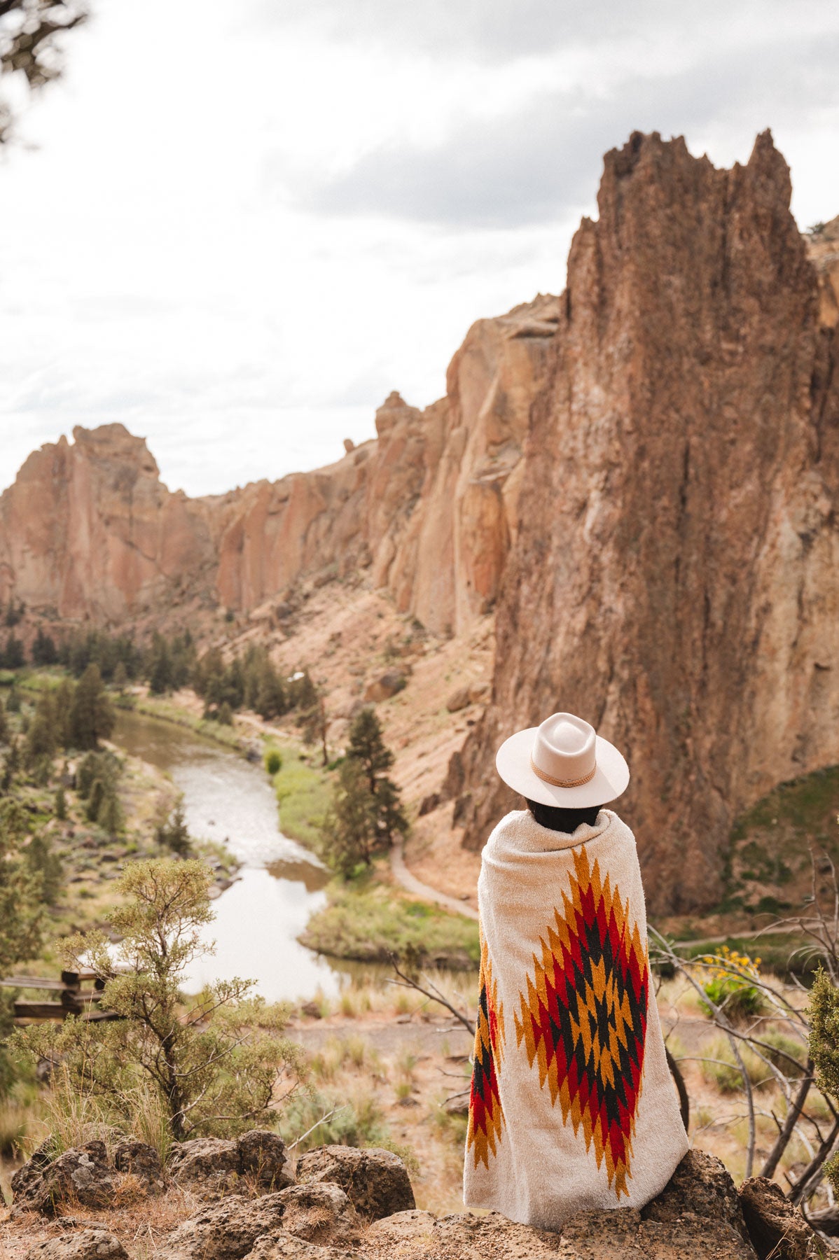 Woman wearing a southwest diamond handwoven blanket at smith rock state park oregon