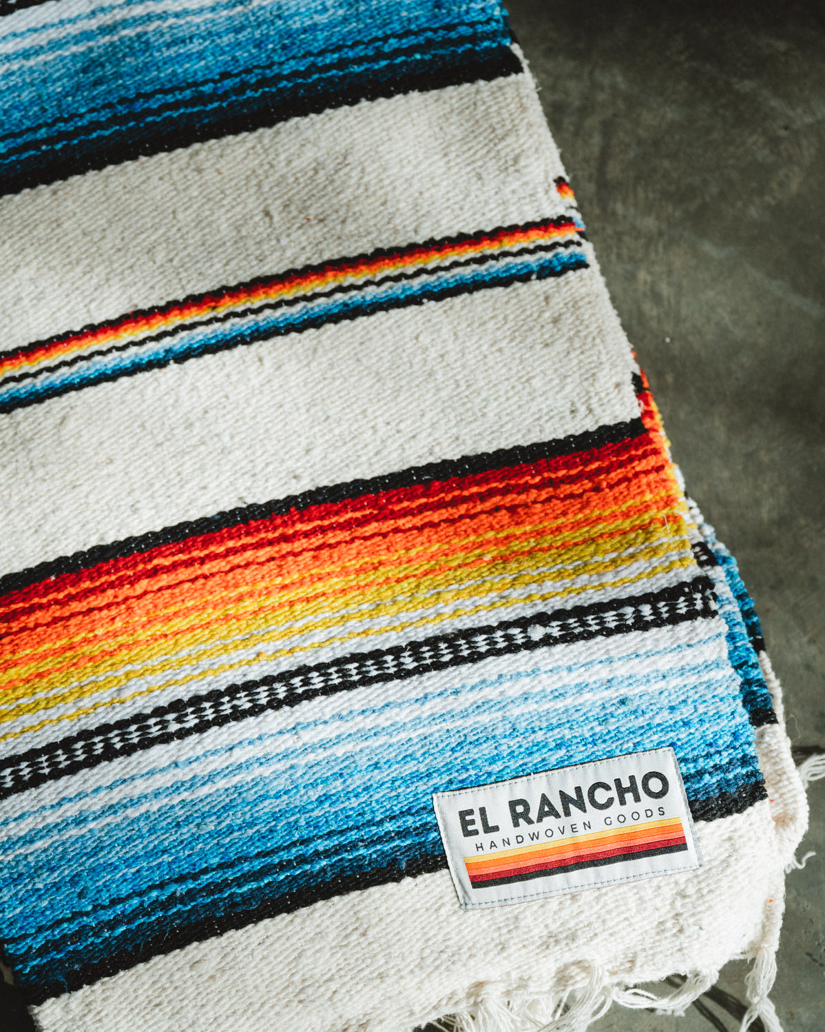 Handwoven socal retro colored saltillo blanket folded on ground