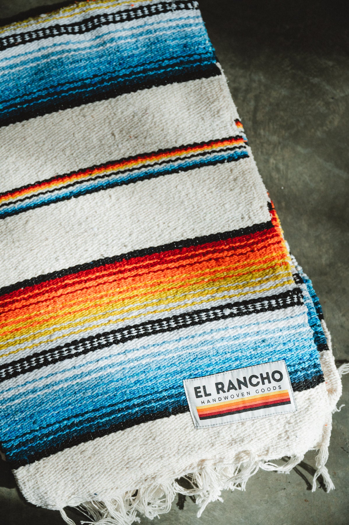 Handwoven socal retro colored saltillo blanket folded on ground