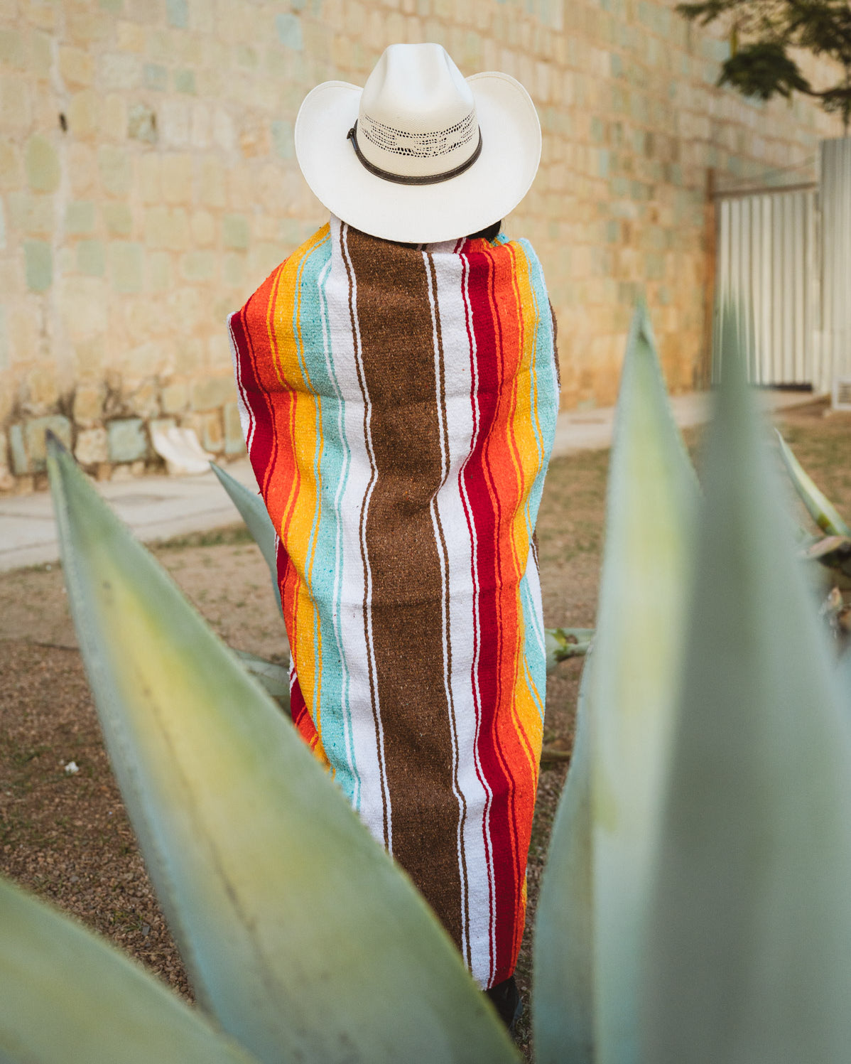 Santo Domingo Church Oaxaca and a girl standing with a handwoven mexican blanket in front of it