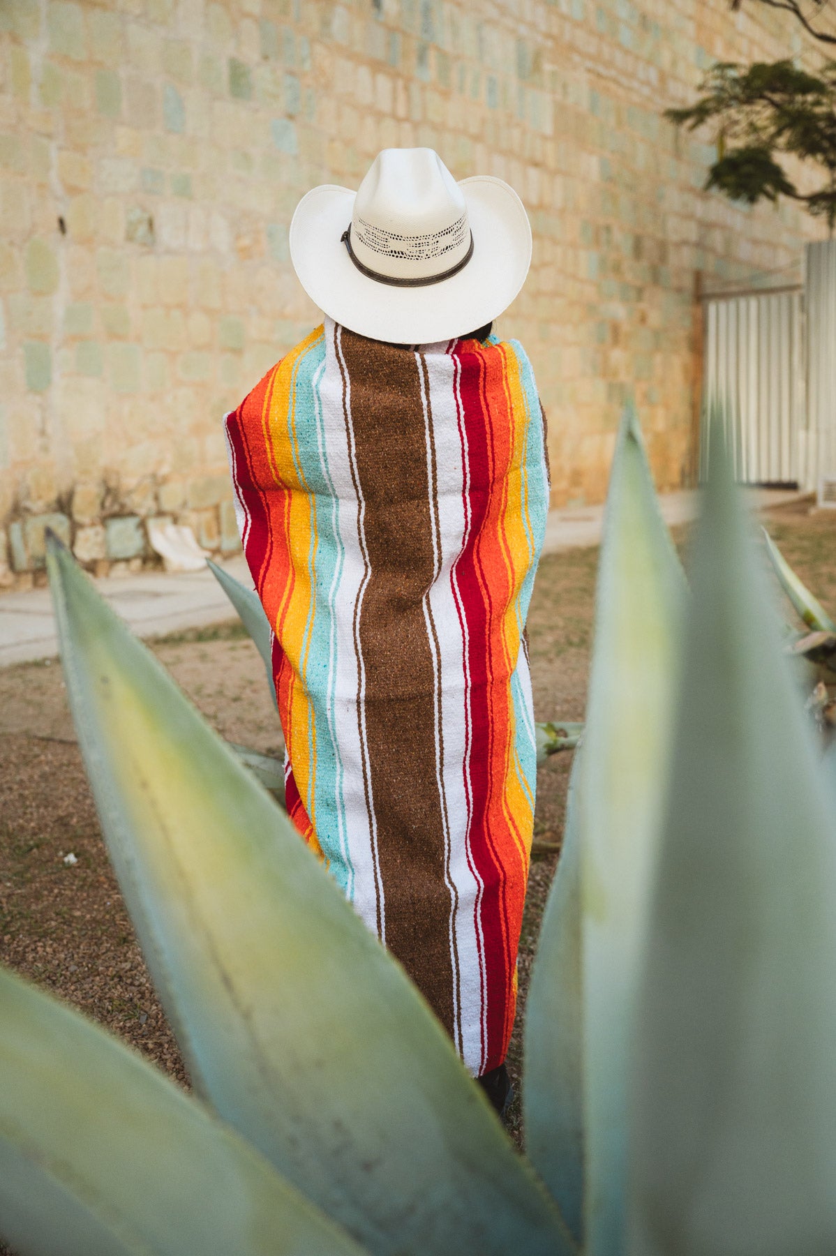 Santo Domingo Church Oaxaca and a girl standing with a handwoven mexican blanket in front of it